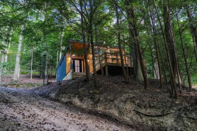 Amid towering hemlocks, this modern cabin reveals the quiet on Hide-A-Way Hills Golf Club in Ohio - for sale on GolfHomes.com, golf home, golf lot