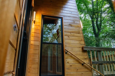 Amid towering hemlocks, this modern cabin reveals the quiet on Hide-A-Way Hills Golf Club in Ohio - for sale on GolfHomes.com, golf home, golf lot