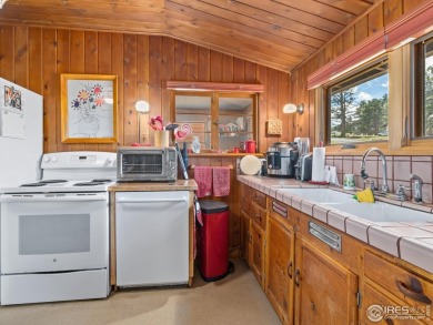 Step inside this charming rustic cabin that offers a peaceful on Estes Park Golf Course in Colorado - for sale on GolfHomes.com, golf home, golf lot