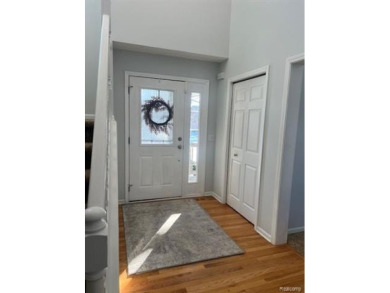 This home's  covered front porch and two story entryway welcomes on Fenton Farms Golf Club in Michigan - for sale on GolfHomes.com, golf home, golf lot