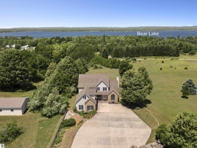 Perched on a quiet hilltop with sweeping views of Bear Lake and on  in Michigan - for sale on GolfHomes.com, golf home, golf lot