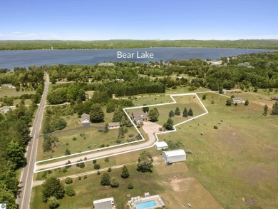Perched on a quiet hilltop with sweeping views of Bear Lake and on  in Michigan - for sale on GolfHomes.com, golf home, golf lot