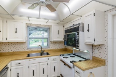 Tucked beneath the shade of moss-draped oaks and overlooking on Tarpon Woods Golf Club in Florida - for sale on GolfHomes.com, golf home, golf lot