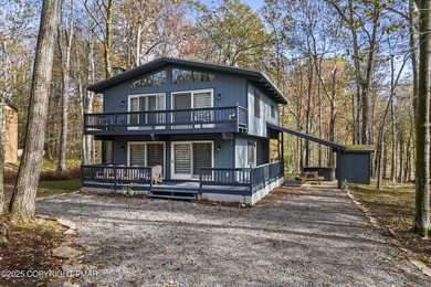 Tucked beneath a canopy of whispering trees, this modern chalet on Pocono Farms Country Club in Pennsylvania - for sale on GolfHomes.com, golf home, golf lot