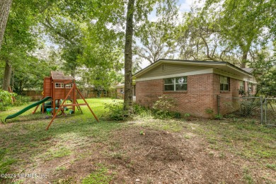 Nestled within a canopy of lush trees, this charming 1960s home on Blue Cypress Golf Club in Florida - for sale on GolfHomes.com, golf home, golf lot