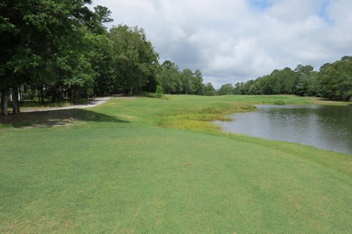 This lovely wooded, over a half acre, lot overlooks the 4th tee on Carolina National Golf Club in North Carolina - for sale on GolfHomes.com, golf home, golf lot