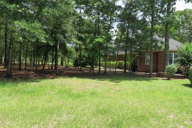 This lovely wooded, over a half acre, lot overlooks the 4th tee on Carolina National Golf Club in North Carolina - for sale on GolfHomes.com, golf home, golf lot