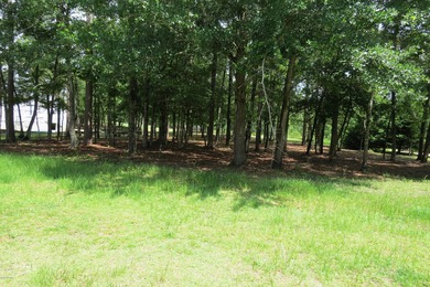 This lovely wooded, over a half acre, lot overlooks the 4th tee on Carolina National Golf Club in North Carolina - for sale on GolfHomes.com, golf home, golf lot