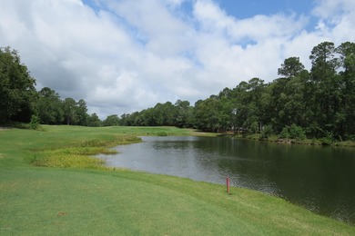 This lovely wooded, over a half acre, lot overlooks the 4th tee on Carolina National Golf Club in North Carolina - for sale on GolfHomes.com, golf home, golf lot