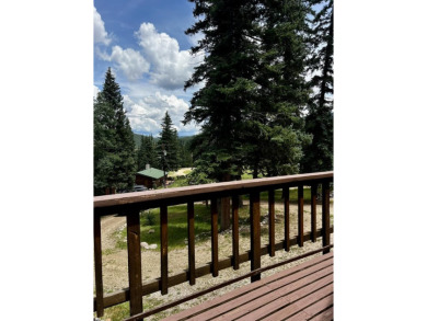 Discover this updated cabin retreat steps from golfing, fishing on El Valle Escondido Golf Course in New Mexico - for sale on GolfHomes.com, golf home, golf lot