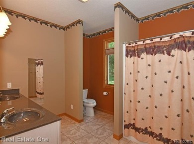 Step inside and discover a thoughtfully designed split ranch on Lost Lake Woods Club in Michigan - for sale on GolfHomes.com, golf home, golf lot