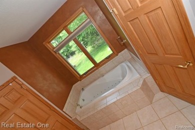 Step inside and discover a thoughtfully designed split ranch on Lost Lake Woods Club in Michigan - for sale on GolfHomes.com, golf home, golf lot
