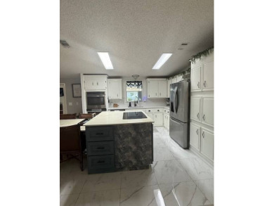 Indulge in expansive living within this magnificent double-wide on Hamptons Golf Club in Florida - for sale on GolfHomes.com, golf home, golf lot