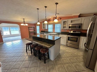 This beautiful triple-wide home, located on the golf course on Four Lakes Golf Club in Florida - for sale on GolfHomes.com, golf home, golf lot