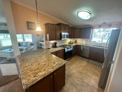 This beautiful Palm Harbour stucco home is located on the golf on Del Tura Golf and Country Club in Florida - for sale on GolfHomes.com, golf home, golf lot