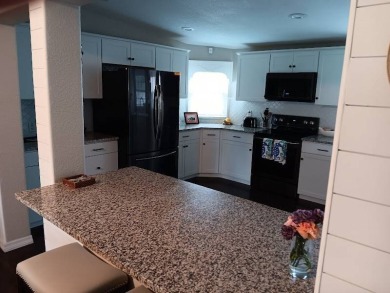 Great kitchen area with pass through counter and open walkway to on Four Lakes Golf Club in Florida - for sale on GolfHomes.com, golf home, golf lot