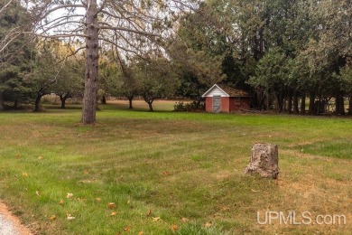 Sitting on a quiet residential street in Hiawatha Township on Indian Lake Golf and Country Club in Michigan - for sale on GolfHomes.com, golf home, golf lot