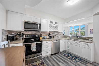 Stunning end unit offering water views galore!  This turnkey on Isla Del Sol Yacht and Country Club in Florida - for sale on GolfHomes.com, golf home, golf lot