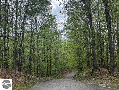 Go beyond the gated entrance, where a wooded winding drive on  in Michigan - for sale on GolfHomes.com, golf home, golf lot