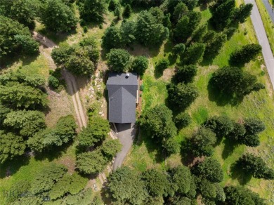 This charming log home, nestled in the trees and perched above on Big Sky of Montana Golf Course in Montana - for sale on GolfHomes.com, golf home, golf lot