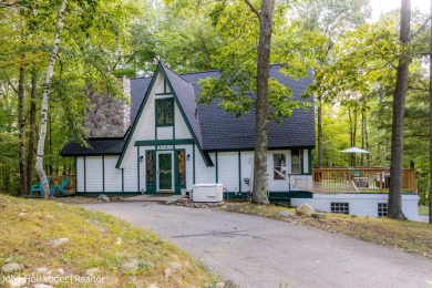 Welcome to this distinctive four-bedroom, three-bath chalet on Canadian Lakes Country Club-The Royal Course in Michigan - for sale on GolfHomes.com, golf home, golf lot