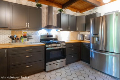 Welcome to this distinctive four-bedroom, three-bath chalet on Canadian Lakes Country Club-The Royal Course in Michigan - for sale on GolfHomes.com, golf home, golf lot