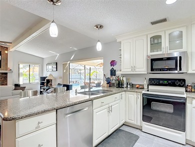 This four bedroom, 3 and a half bathroom pool home is nestled in on Tampa Palms Golf and Country Club in Florida - for sale on GolfHomes.com, golf home, golf lot