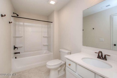 Welcome to this beautifully appointed 4-bedroom, 3-bath home on Carolina National Golf Club in North Carolina - for sale on GolfHomes.com, golf home, golf lot