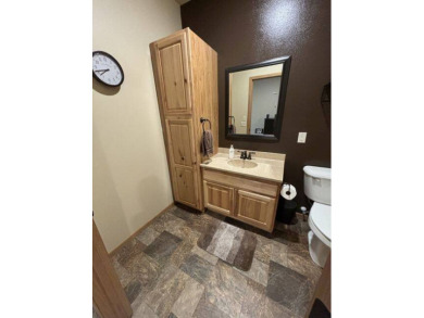 Nestled on a serene treed lot, this stunning one-story on Devils Lake Town and Country Club in North Dakota - for sale on GolfHomes.com, golf home, golf lot