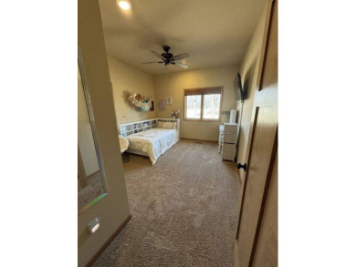 Nestled on a serene treed lot, this stunning one-story on Devils Lake Town and Country Club in North Dakota - for sale on GolfHomes.com, golf home, golf lot