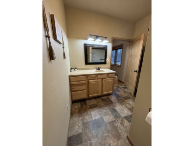 Nestled on a serene treed lot, this stunning one-story on Devils Lake Town and Country Club in North Dakota - for sale on GolfHomes.com, golf home, golf lot