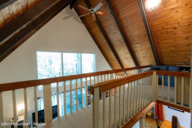 Welcome to this distinctive four-bedroom, three-bath chalet on Canadian Lakes Country Club-The Royal Course in Michigan - for sale on GolfHomes.com, golf home, golf lot