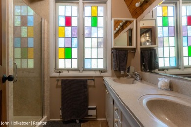 Welcome to this distinctive four-bedroom, three-bath chalet on Canadian Lakes Country Club-The Royal Course in Michigan - for sale on GolfHomes.com, golf home, golf lot