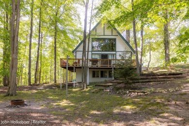 Welcome to this distinctive four-bedroom, three-bath chalet on Canadian Lakes Country Club-The Royal Course in Michigan - for sale on GolfHomes.com, golf home, golf lot