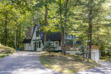 Welcome to this distinctive four-bedroom, three-bath chalet on Canadian Lakes Country Club-The Royal Course in Michigan - for sale on GolfHomes.com, golf home, golf lot