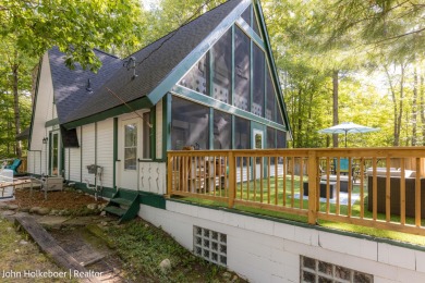Welcome to this distinctive four-bedroom, three-bath chalet on Canadian Lakes Country Club-The Royal Course in Michigan - for sale on GolfHomes.com, golf home, golf lot