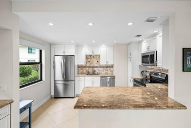 Exceptional golf course views wrap around this renovated on Quail Ridge Golf Course and Country Club in Florida - for sale on GolfHomes.com, golf home, golf lot