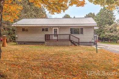 Sitting on a quiet residential street in Hiawatha Township on Indian Lake Golf and Country Club in Michigan - for sale on GolfHomes.com, golf home, golf lot