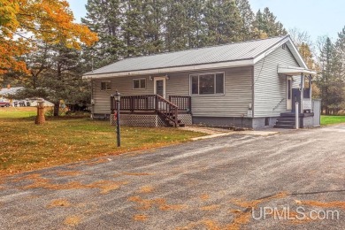 Sitting on a quiet residential street in Hiawatha Township on Indian Lake Golf and Country Club in Michigan - for sale on GolfHomes.com, golf home, golf lot