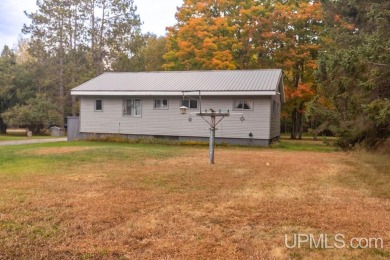 Sitting on a quiet residential street in Hiawatha Township on Indian Lake Golf and Country Club in Michigan - for sale on GolfHomes.com, golf home, golf lot