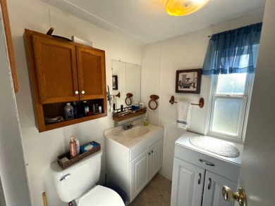 This charming home features two bedrooms and one and a half on Lake Henry Golf Club in Florida - for sale on GolfHomes.com, golf home, golf lot