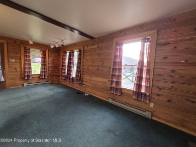 Check out this 3-bedroom, 1-bathroom log home! Featuring a cozy on Rock Creek Golf Course in Pennsylvania - for sale on GolfHomes.com, golf home, golf lot