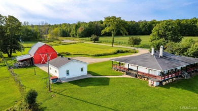 This picture perfect farmhouse sits nestled in the fields at the on Hiawatha Sportsmans Golf Club in Michigan - for sale on GolfHomes.com, golf home, golf lot