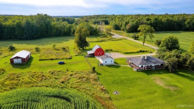 This picture perfect farmhouse sits nestled in the fields at the on Hiawatha Sportsmans Golf Club in Michigan - for sale on GolfHomes.com, golf home, golf lot