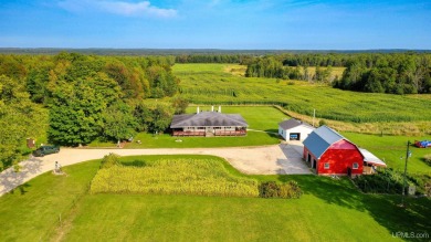 This picture perfect farmhouse sits nestled in the fields at the on Hiawatha Sportsmans Golf Club in Michigan - for sale on GolfHomes.com, golf home, golf lot