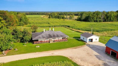 This picture perfect farmhouse sits nestled in the fields at the on Hiawatha Sportsmans Golf Club in Michigan - for sale on GolfHomes.com, golf home, golf lot