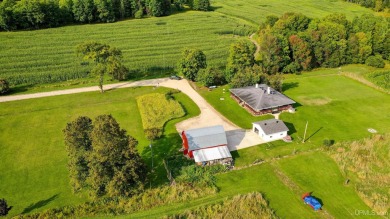 This picture perfect farmhouse sits nestled in the fields at the on Hiawatha Sportsmans Golf Club in Michigan - for sale on GolfHomes.com, golf home, golf lot