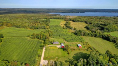 This picture perfect farmhouse sits nestled in the fields at the on Hiawatha Sportsmans Golf Club in Michigan - for sale on GolfHomes.com, golf home, golf lot