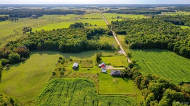 This picture perfect farmhouse sits nestled in the fields at the on Hiawatha Sportsmans Golf Club in Michigan - for sale on GolfHomes.com, golf home, golf lot