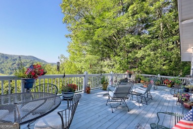 A Wrap Around Covered Porch, full of beautiful plants, welcomes on Sky Valley Resort and Country Club in Georgia - for sale on GolfHomes.com, golf home, golf lot